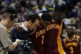 Dec 31, 2013; Indianapolis, IN, USA;  Cleveland Cavaliers point guard Kyrie Irving (2) is helped off the court after being injured during the third quarter against the Indiana Pacers at Bankers Life Fieldhouse. The Pacers won 91-76.  Mandatory Credit: Pat
