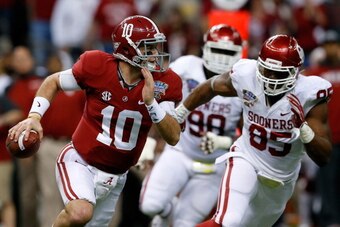 NEW ORLEANS, LA - JANUARY 02:  AJ McCarron #10 of the Alabama Crimson Tide runs with the ball past Geneo Grissom #85 of the Oklahoma Sooners during the Allstate Sugar Bowl at the Mercedes-Benz Superdome on January 2, 2014 in New Orleans, Louisiana.  (Phot