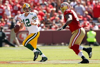 Sep 8, 2013; San Francisco, CA, USA; Green Bay Packers quarterback Aaron Rodgers (12) is chased by San Francisco 49ers defensive tackle Ray McDonald (91) in the second quarter at Candlestick Park. The 49ers defeated the Packers 34-28. Mandatory Credit: Ca