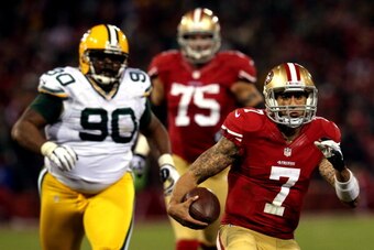 SAN FRANCISCO, CA - JANUARY 12:  Quarterback Colin Kaepernick #7 of the San Francisco 49ers runs the ball against nose tackle B.J. Raji #90 of the Green Bay Packers during the NFC Divisional Playoff Game at Candlestick Park on January 12, 2013 in San Fran