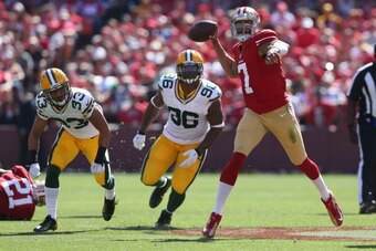 SAN FRANCISCO, CA - SEPTEMBER 08:  Quarterback Colin Kaepernick #7 of the San Francisco 49ers is pursued by Micah Hyde #33 and Mike Neal #96 of the Green Bay Packers at Candlestick Park on September 8, 2013 in San Francisco, California.  (Photo by Jeff Gr