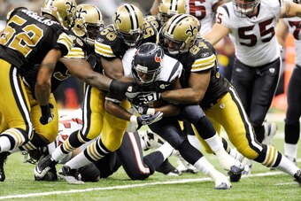 NEW ORLEANS, LA - SEPTEMBER 25:  Cameron Jordan #94 and Jo-Lonn Dunbar #56 of the New Orleans Saints bring down Ben Tate #44 of the Houston Texans during a game being held at the Louisiana Superdome on September 25, 2011 in New Orleans, Louisiana.  The Sa