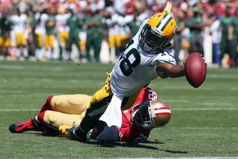 SAN FRANCISCO, CA - SEPTEMBER 08:  Randall Cobb #18 of the Green Bay Packers stretches across the goal line for a touchdown while being pulled down by Carlos Rogers #22 of the San Francisco 49ers in the first quarter at Candlestick Park on September 8, 20