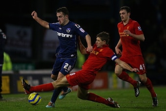 OLDHAM, ENGLAND - JANUARY 27:  Jose Baxter of Oldham competes with Steven Gerrard of Liverpool during the FA Cup with Budweiser Fourth Round match between Oldham Athletic and Liverpool at Boundary Park on January 27, 2013 in Oldham, England.  (Photo by Al