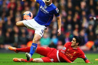 LIVERPOOL, ENGLAND - JANUARY 05:  James Wesolowski of Oldham is tackled by Luis Alberto of Liverpool during the Budweiser FA Cup third round match between Liverpool and Oldham Athletic at Anfield on January 5, 2014 in Liverpool, England.  (Photo by Clive 