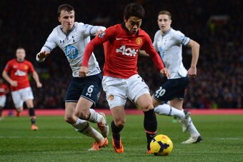 MANCHESTER, ENGLAND - JANUARY 01:  Shinji Kagawa of Manchester United competes with Vlad Chiriches of Tottenham Hotspur during the Barclays Premier League match between Manchester United and Tottenham Hotspur at Old Trafford on January 1, 2014 in Manchest