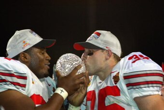 TEMPE, AZ - JANUARY 3:  Kenny Peterson #97 (l) and Matt Wilheim #35 of the Ohio State Buckeyes celebrate with the National Championship trophy after defeating the Miami Hurricanes 31-24 in double overtime the Tostitos Fiesta Bowl on January 3, 2003 at Sun