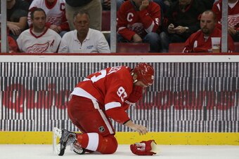 DETROIT, MI - NOVEMBER 27: Johan Franzen #93 of the Detroit Red Wings goes to his knees after a collision late in the first period of the game against the Boston Bruins at Joe Louis Arena on November 27, 2013 in Detroit, Michigan.  (Photo by Leon Halip/Ge