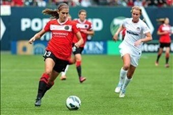 May 19, 2013; Portland, OR, USA; Portland Thorns forward Alex Morgan (13) brings the ball up the field past Washington Spirit midfielder Julia Roberts (13) during the first half of the game at Jeld-Wen Field. Mandatory Credit: Steve Dykes-USA TODAY Sports