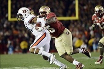 Jan 6, 2014; Pasadena, CA, USA; Auburn Tigers quarterback Nick Marshall (14) is tackled by Florida State Seminoles defensive end Mario Edwards Jr. (15) during the second half of the 2014 BCS National Championship game at the Rose Bowl.  Mandatory Credit: 