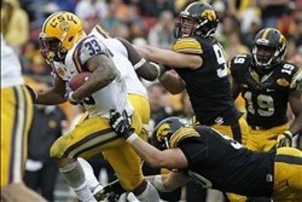 Jan 1, 2014; Tampa, Fl, USA; LSU Tigers running back Jeremy Hill (33) runs past Iowa Hawkeyes defensive lineman Louis Trinca-Pasat (90)  during the second half at Raymond James Stadium. LSU Tigers defeated the Iowa Hawkeyes 21-14. Mandatory Credit: Kim Kl