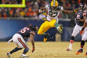Dec 29, 2013; Chicago, IL, USA; Green Bay Packers running back Eddie Lacy (27) leaps over Chicago Bears cornerback Tim Jennings (26) during the second quarter at Soldier Field. Mandatory Credit: Dennis Wierzbicki-USA TODAY Sports