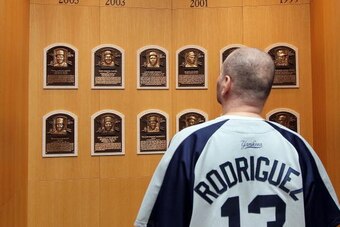COOPERSTOWN, NY - JULY 24:  A patron of the Baseball Hall of Fame and Museum views the plaques of inducted members during induction weekend on July 24, 2010 in Cooperstown, New York.  (Photo by Jim McIsaac/Getty Images)
