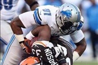 Aug 15, 2013; Cleveland, OH, USA; Cleveland Browns running back Trent Richardson (33) is tackled by Detroit Lions defensive end Jason Jones (91) and defensive end Ezekiel Ansah (94) during the first quarter at FirstEnergy Field. Mandatory Credit: Ron Schw