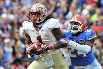 Nov 30, 2013; Gainesville, FL, USA; Florida State Seminoles wide receiver Kelvin Benjamin (1) runs in a touchdown as Florida Gators defensive back Brian Poole (24) defends during the second quarter at Ben Hill Griffin Stadium. Mandatory Credit: Steve Mitc