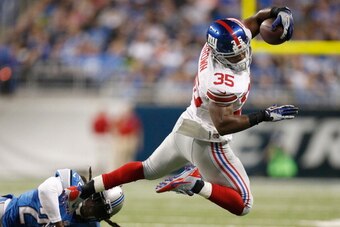 DETROIT, MI - DECEMBER 22: Andre Brown #35 of the New York Giants tries to get around the tackle of Louis Delmas #26 of the Detroit Lions during a second quarter run at Ford Field on December 22, 2013 in Detroit, Michigan. (Photo by Gregory Shamus/Getty I