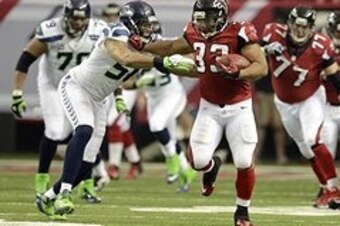 Jan 13, 2013; Atlanta, GA, USA; Atlanta Falcons running back Michael Turner (33) stiff arms Seattle Seahawks outside linebacker K.J. Wright (50) during the second quarter in the NFC divisional playoff game at the Georgia Dome. Mandatory Credit: John David