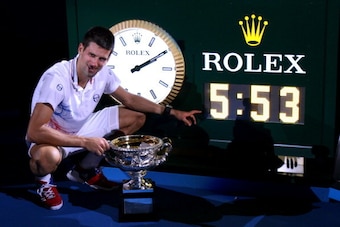 MELBOURNE, AUSTRALIA - JANUARY 29:  Novak Djokovic of Serbia poses with the Norman Brookes Challenge Cup and the clock after winning championship point and playing in the longest grand slam final ever in his men's final match against Rafael Nadal of Spain