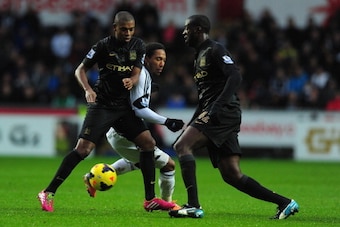 SWANSEA, WALES - JANUARY 01:  Manchester City players Fernandinho (l) and Yaya Toure (r) combine to halt Jonathan de Guzman during the Barclays Premier League match between Swansea City and Manchester City at Liberty Stadium on January 1, 2014 in Swansea,