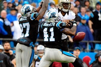 CHARLOTTE, NC - DECEMBER 22:  Captain Munnerlyn #41 and Quintin Mikell #27 of the Carolina Panthers break up a pass intended for Marques Colston #12 of the New Orleans Saints during their game at Bank of America Stadium on December 22, 2013 in Charlotte, 