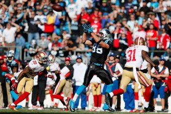 CHARLOTTE, NC - JANUARY 12: Greg Olsen #88 of the Carolina Panthers makes a catch against Perrish Cox #20 and Donte Whitner #31 of the San Francisco 49ers in the second quarter during the NFC Divisional Playoff Game at Bank of America Stadium on January 1