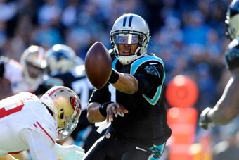 CHARLOTTE, NC - JANUARY 12: Cam Newton #1 of the Carolina Panthers pitches the ball against the San Francisco 49ers in the second quarter during the NFC Divisional Playoff Game at Bank of America Stadium on January 12, 2014 in Charlotte, North Carolina.  
