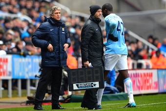 NEWCASTLE UPON TYNE, ENGLAND - JANUARY 12:  The injured Yaya Toure of Manchester City speaks to Manuel Pellegrini the Manchester City manager as he leaves the pitch due to injury during the Barclays Premier League match between Newcastle United and Manche