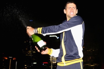 MELBOURNE, AUSTRALIA - JANUARY 28:  Novak Djokovic of Serbia celebrates with a bottle of champagne in the early hours of January 28, 2013 after winning his men's final match against Andy Murray of Great Britain during day fourteen of the 2013 Australian O