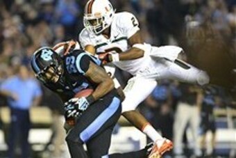 Oct 17, 2013; Chapel Hill, NC, USA; North Carolina Tar Heels tight end Eric Ebron (85) catches the ball as Miami Hurricanes defensive back Deon Bush (2) defends in the second quarter at Kenan Memorial Stadium. Mandatory Credit: Bob Donnan-USA TODAY Sports