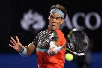 MELBOURNE, AUSTRALIA - JANUARY 14:  Rafael Nadal of Spain plays a forehand in his first round match against Bernard Tomic of Australia  during day two of the 2014 Australian Open at Melbourne Park on January 14, 2014 in Melbourne, Australia.  (Photo by Cl