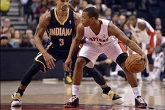 Jan 1, 2014; Toronto, Ontario, CAN; Toronto Raptors point guard Kyle Lowry (7) tries to get the ball past Indiana Pacers point guard George Hill (3) during the fourth quarter of a game at the Air Canada Centre. Toronto won the game  95-82. Mandatory Credi