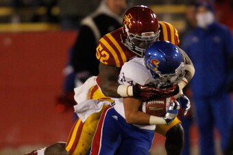 Nov 23, 2013; Ames, IA, USA; Iowa State Cyclones defender Jeremiah George (52) tackles Kansas Jayhawks running back Connor Embree (34) in the fourth quarter at Jack Trice Stadium. Iowa State won 34-0. Mandatory Credit: Bruce Thorson-USA TODAY Sports