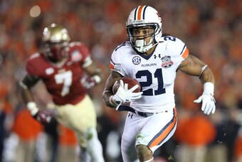 Jan 6, 2014; Pasadena, CA, USA; Auburn Tigers running back Tre Mason (21) carries the ball past Florida State Seminoles linebacker Christian Jones (7) during the first half of the 2014 BCS National Championship game at the Rose Bowl.  Mandatory Credit: Ma