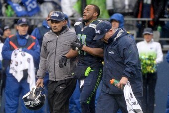 SEATTLE, WA - JANUARY 11:  Wide receiver Percy Harvin #11 of the Seattle Seahawks is helped off the field late in the second quarter against the New Orleans Saints during the NFC Divisional Playoff Game at CenturyLink Field on January 11, 2014 in Seattle,