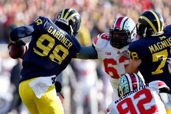 ANN ARBOR, MI - NOVEMBER 30:  Quarterback Devin Gardner #98 of the Michigan Wolverines avoids a third quarter sack by defensive lineman Michael Bennett #63 of the Ohio State Buckeyes during a game at Michigan Stadium on November 30, 2013 in Ann Arbor, Mic