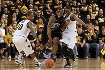 March 2, 2013; Richmond, VA USA;  Butler Bulldogs forward Roosevelt Jones (21) dribbles the ball as Virginia Commonwealth Rams guard Darius Theus (10) and Rams guard Rob Brandenberg (11) defend in the first half at the Siegel Center. The Rams won 84-52. M
