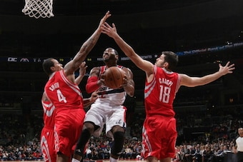 WASHINGTON, DC - JANUARY 11: John Wall #2 of the Washington Wizards shoots against Terrence Jones #4 and Omri Casspi #18 of the Houston Rockets during the game at the Verizon Center on January 11, 2014 in Washington, DC. NOTE TO USER: User expressly ackno