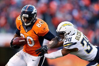 DENVER, CO - JANUARY 12:  Julius Thomas #80 of the Denver Broncos tries to avoid the tackle of  Marcus Gilchrist #38 of the San Diego Chargers during the AFC Divisional Playoff Game at Sports Authority Field at Mile High on January 12, 2014 in Denver, Col