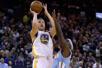 OAKLAND, CA - JANUARY 15:  Klay Thompson #11 of the Golden State Warriors shoots over Ty Lawson #3 of the Denver Nuggets at ORACLE Arena on January 15, 2014 in Oakland, California. NOTE TO USER: User expressly acknowledges and agrees that, by downloading