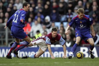BIRMINGHAM, ENGLAND  - DECEMBER 17:  James Milner of Aston Villa is shut out by John O'Shea and Darren Fletcher of Manchester Utd during the Barclay's Premiership match between Aston Villa and Manchester Utd at Villa Park on December 17, 2005, in Birmingh