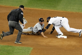 Oct 14, 2012; Bronx, NY, USA; Second base umpire Jeff Nelson (left) watches as Detroit Tigers second baseman Omar Infante (in grey) tries to dive back to second base against New York Yankees second baseman Robinson Cano in the 8th inning during game two o