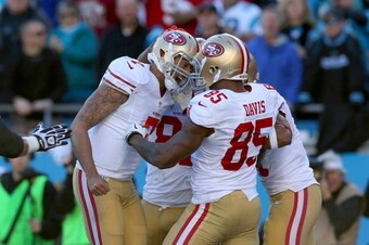 CHARLOTTE, NC - JANUARY 12:  Colin Kaepernick #7 of the San Francisco 49ers celebrates with teammates after a touchdown in the third quarter against the Carolina Panthers during the NFC Divisional Playoff Game at Bank of America Stadium on January 12, 201