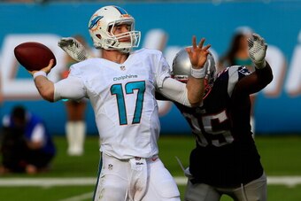 MIAMI GARDENS, FL - DECEMBER 15:  Ryan Tannehill #17 of the Miami Dolphins attempts to pass the ball under pressure from  Chandler Jones #95 of the New England Patriots at Sun Life Stadium on December 15, 2013 in Miami Gardens, Florida.  (Photo by Chris T