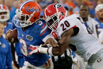 JACKSONVILLE, FL - NOVEMBER 02:  Quincy Mauger #20 of the Georgia Bulldogs attempts to tackle Tyler Murphy #3 of the Florida Gators during the game at EverBank Field on November 2, 2013 in Jacksonville, Florida.  (Photo by Sam Greenwood/Getty Images)