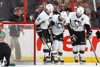 OTTAWA, ON - DECEMBER 23: Pascal Dupuis #9 of the Pittsburgh Penguins is helped off the ice by team mates Matt Niskanen #2 and Chris Kunitz #14 after colliding with his own player during an NHL game against the Ottawa Senators at Canadian Tire Centre on D