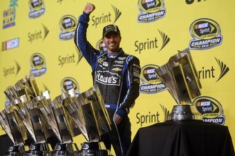 Nov 17, 2013; Homestead, FL, USA; NASCAR Sprint Cup Series driver Jimmie Johnson poses for a photo with six Sprint Cup championship trophies after the Ford EcoBoost 400 at Homestead-Miami Speedway. Mandatory Credit: Jerry Lai-USA TODAY Sports
