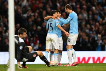 MANCHESTER, ENGLAND - JANUARY 18: Sergio Aguero of Manchester City celebrates with teammates Jesus Navas (L) and Edin Dzeko (R) after scoring his team's fourth goal during the Barclays Premier League match between Manchester City and Cardiff City at the MANCHESTER, ENGLAND - JANUARY 18: Sergio Aguero of Manchester City celebrates with teammates Jesus Navas (L) and Edin Dzeko (R) after scoring his team's fourth goal during the Barclays Premier League match between Manchester City and Cardiff City at the