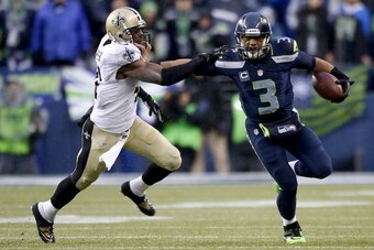 SEATTLE, WA - JANUARY 11:  Quarterback Russell Wilson #3 of the Seattle Seahawks pushes back strong safety Roman Harper #41 of the New Orleans Saints in the fourth quarter while taking on the New Orleans Saints during the NFC Divisional Playoff Game at Ce