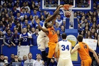 Jan 18, 2014; Lawrence, KS, USA; Kansas Jayhawks center Joel Embiid (21) dunks the ball against in Oklahoma State Cowboys guard Marcus Smart (33) the first half at Allen Fieldhouse. Mandatory Credit: John Rieger-USA TODAY Sports