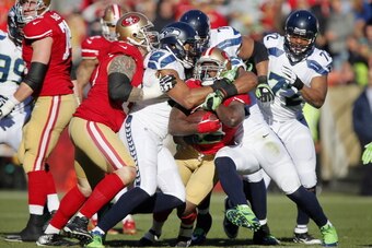 SAN FRANCISCO, CA - DECEMBER 08:  Running back Frank Gore #21 of the San Francisco 49ers gets ganged up on by linebacker K.J. Wright #50 and free safety Earl Thomas #29 of the Seattle Seahawks in the first quarter on December 8, 2013 at Candlestick Park i